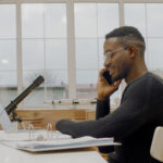 African American male remote working from home, having work phone call. Stay home, quarantine remote work